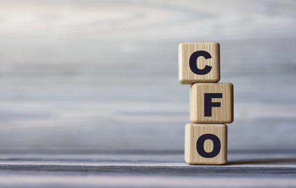 CFO (Chief Financial Officer) - word on wooden cubes against the background of a light board with beautiful divorces. Business and Technology concept.