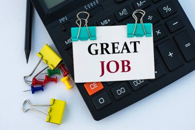 Harika bir iş - beyaz arka planda klipsleri olan, hesap makinesi, düğmeler ve sarı kırtasiye klipleri olan beyaz bir sayfa üzerinde kelimeler. İnternet kavramı