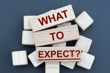 Ne beklenir ki? - Tahta parmaklıklarda, küplerde, gri arka planda kelimeler. İş ve finans kavramı