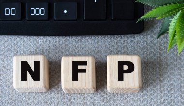 NFP - hesaplayıcılı gri arkaplandaki tahta küplerin kısaltması. İş konsepti