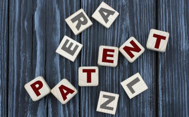 Küpler üzerinde güzel, gri bir arka planda konsept kelime PATENT. İş konsepti