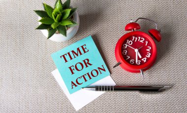 Eylem Zamanı - Kaktüs ve çalar saatle birlikte gri arka plan üzerine yazılmış kağıt üzerindeki kelimeler. İş konsepti