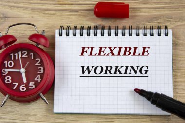 FLEXIBLE çalışıyor - ahşap bir arkaplanda, bir çalar saat ve bir işaret ile bir defterde kelimeler. İş konsepti