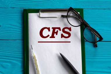 CFS (Kronik Yorgunluk Sendromu) - mavi arkaplandaki bir not defterinin kısaltması, kalem, gözlük ve termometre ile. Tıbbi konsept