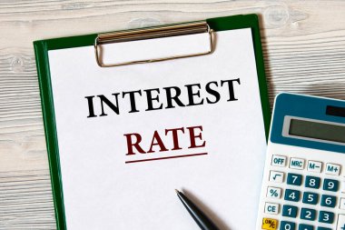 İlginç Oranlar - Hesap makinesi ve kalemle hafif ahşap zemin üzerinde bir defter üzerindeki sözcükler