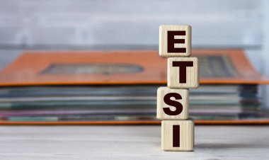 ETSI (Avrupa Telekomünikasyon Standartları Enstitüsü) - belgeli bir klasörün arka planındaki tahta küplerle ilgili kelime. İş konsepti