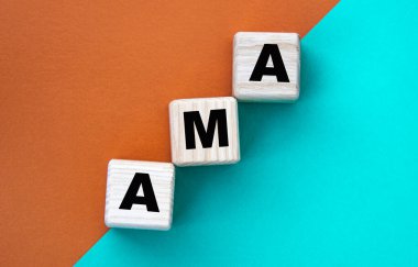 AMA - acronym on wooden cubes on a multi-colored background. Info concept clipart