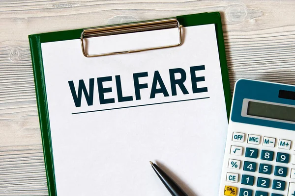 Welfare Woord Een Notitieboekje Een Lichte Houten Ondergrond Met Rekenmachine — Stockfoto
