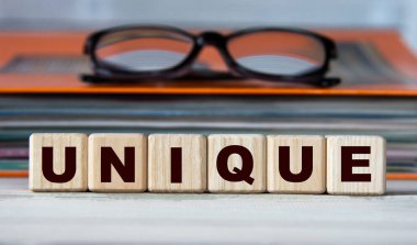 UNIQUE - evrak ve gözlüklü bir klasörün arka planındaki tahta küplerle ilgili bir kelime. Bilgi kavramı