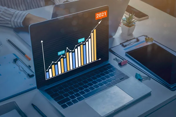 AR (Artırılmış gerçeklik) finansal grafikleri 2021 yılında dijital ekran dizüstü bilgisayarının üzerinde yükselen gelirleri, iş adamlarının büyüme ve başarı stratejisi hakkında toplantı yaptıklarını gösteriyor.