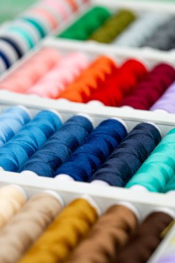 Farklı renklerde iplikler. Dikiş ve dikiş işleri için çok renkli iplikler. Farklı renkte küçük iplik ruloları.