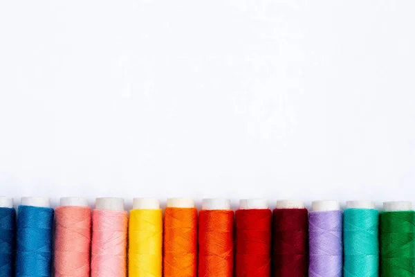 Colourful sewing threads on white background, top view. Spools of thread in different colors. — Stock Photo, Image