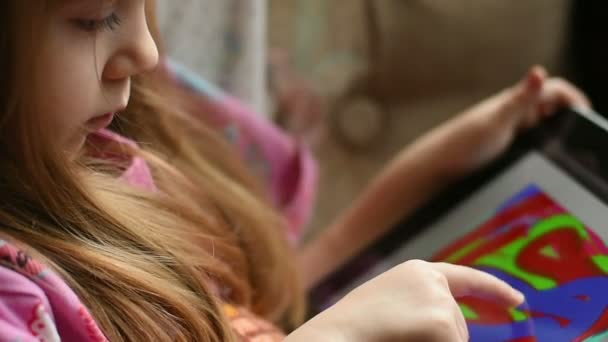 Маленькая девочка рисует на планшете — стоковое видео