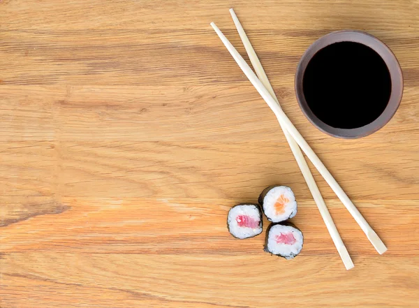 Somon rollsi, yemek çubukları ve soya sosu ahşap tablo,