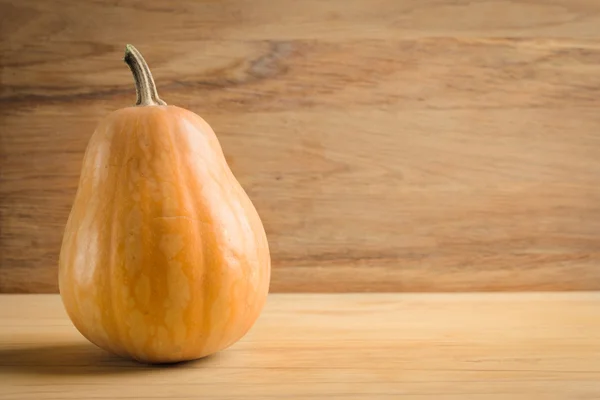 Een pompoen op een houten achtergrond van grunge. — Stockfoto