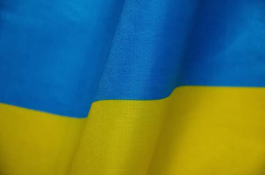 Ukrayna bayrağının bir parçası. Dalgalı mavi-sarı kumaşın yüzeyi. Üst manzara, düz yatış. Saten yüzey. Bağımsızlık kavramı.