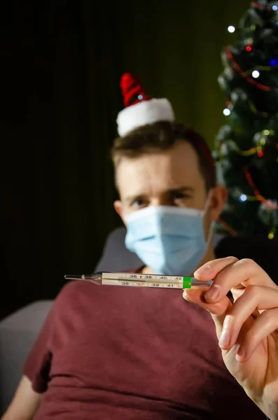 Hombre Caucásico Con Máscara Médica Protectora Sombrero Navidad Sosteniendo Termómetro — Foto de Stock