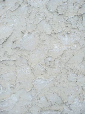 Binanın ön cephesinde bej bir alçı var. Soyut grunge dekoratif duvar dokusu. Metin için kopyalama alanı olan pürüzlü arkaplan. Çok güzel bir duvar örülmüş..