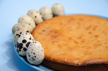 Paskalya bayrağınız kutlu olsun. Seçici odak pastası ve bıldırcın yumurtaları mavi arka planda, fotokopi alanında. Tatil için hazırlık.