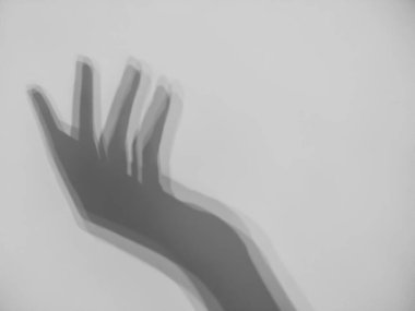 Gri arka planda kadın elinin gölgesi. Kopya alanı olan zarif bir kadın el gölgesi. Kendini sevme, kendini koruma konsepti. Bulanık efekt.