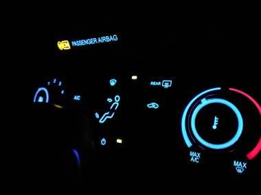 Arabada seçici odak odaklı gösterge paneli. Arabada elektronik paneldeki gece modu. Neon mavi ve kırmızı aydınlatma düğmeleri ve belirti koyu.