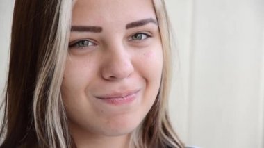 Genç bayan iğrendi. Diş teli takan esmer genç kız. Yeşil gözlü güzel, beyaz bir kız iğrenç bir şey düşünüyor. Gençlik konsepti. Diş telleriyle diş hizalaması.