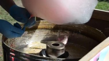 Pamuk helvadan çiçek yapma süreci. Pamuk helva üretmek, şekeri ısıtmak ve şeker telleri yaratmak için şekerli aparatlar..