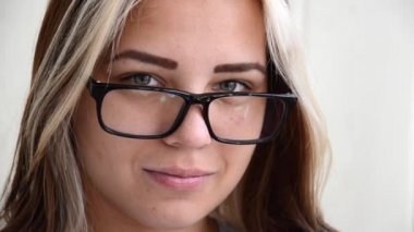 Gözlüklü esmer genç kadın. Meslek seçme kavramı. Yeşil gözlü güzel beyaz kız kameraya bakıyor ve gülümsüyor. Öğrenci, izinsiz giren ya da genç çalışan. 