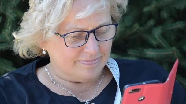 Donna Caucasica Adulta Con Occhiali Legge Intensamente Informazioni Telefono Con — Video Stock