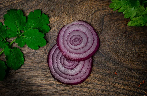 Onion slices on a wooden cutting board.