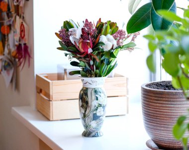 Oturma odasındaki vazoda bir buket çiçek..