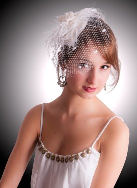 Genç kız bir örtü ile kokteyl bir şapka.