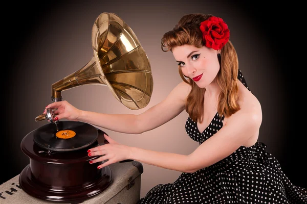 Beautiful young pin-up listens to retro gramophone — Stock Photo, Image