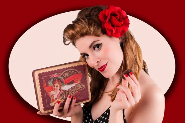 Mooie jonge pin-up girl genoot op chocoladesuikergoed snoep. Rechtenvrije Stockafbeeldingen