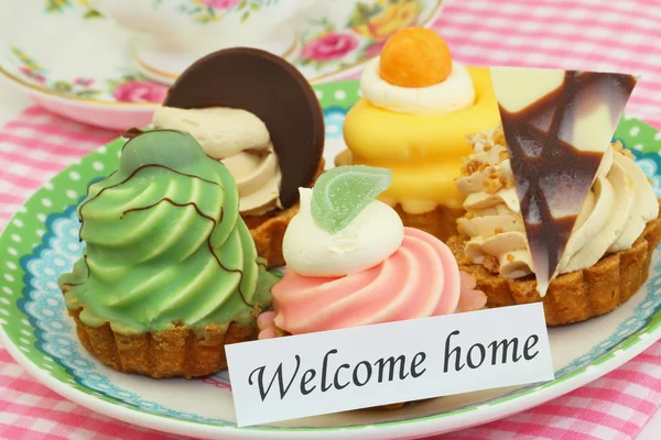 Welcome home card with colorful cream cakes — Stock Photo, Image