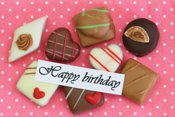 Feliz cartão de aniversário com seleção de chocolates em fundo rosa — Fotografia de Stock