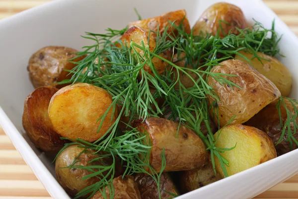 Roasted baby potatoes garnished with fresh dill, close up — Stock Photo, Image
