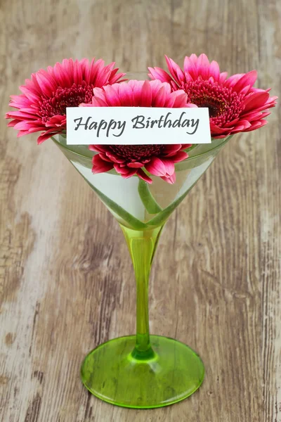 Cartão de aniversário feliz com margaridas gerbera rosa em vidro martini — Fotografia de Stock