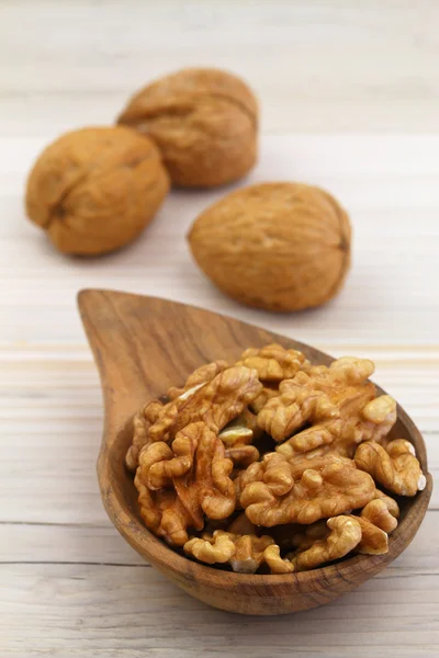 Walnuts with and without shell on wooden background — Stock Photo, Image