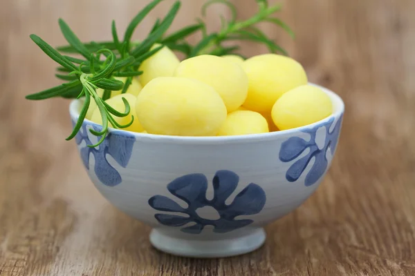 Batatas de bebê com alecrim fresco em tigela de porcelana — Fotografia de Stock