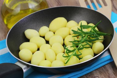 Bebek patates kızartma tavası içinde taze biberiye ile