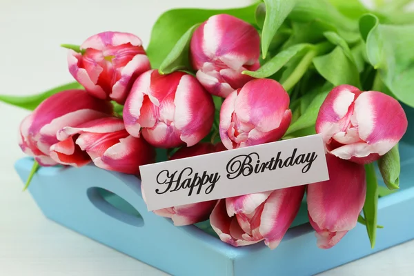 Feliz aniversário com tulipas rosa na bandeja azul — Fotografia de Stock