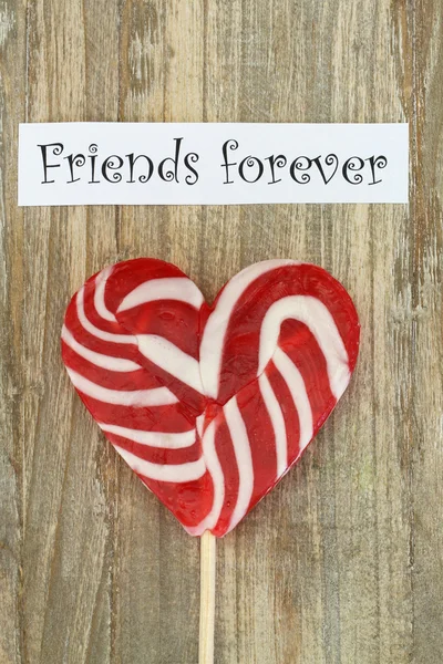 Friends forever Karte mit herzförmigem Lutscher auf Holzoberfläche — Stockfoto