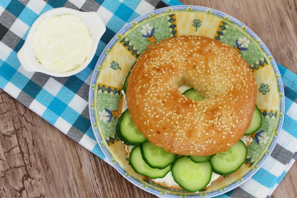 Bagel com creme de queijo, pepino e agrião, de perto — Fotografia de Stock