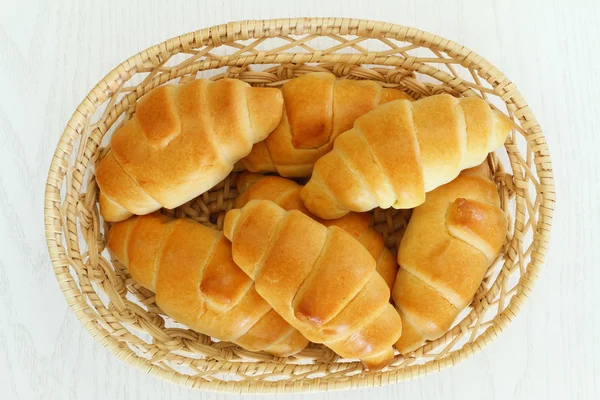 Круассаны с маслом в хлебной корзине, изолированные на белом — стоковое фото