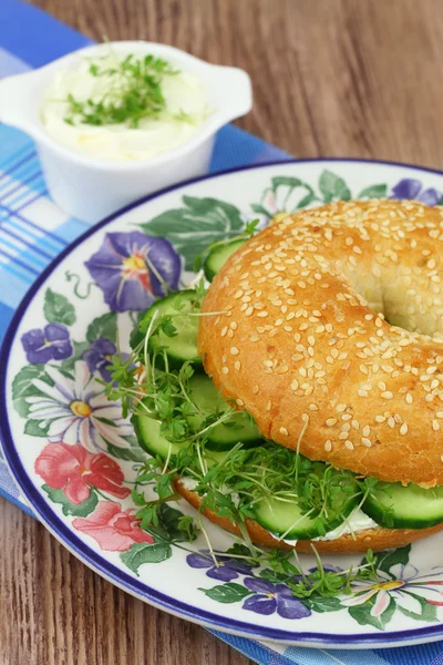 Bagel met roomkaas, komkommer en waterkers, close-up — Stockfoto