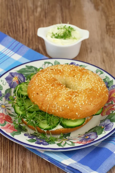 Bagel met roomkaas, komkommer en waterkers, close-up — Stockfoto