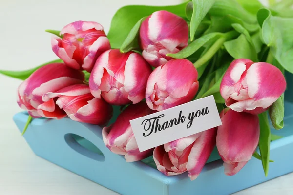 Dankeskarte mit rosa Tulpen auf blauem, hölzernem Tablett — Stockfoto