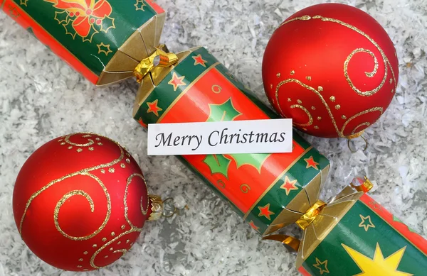 Merry Christmas card med röda grannlåt och jul cracker — Stockfoto