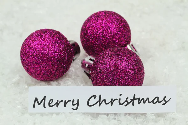 Feliz tarjeta de Navidad con bolas púrpuras, en la superficie nevada — Foto de Stock
